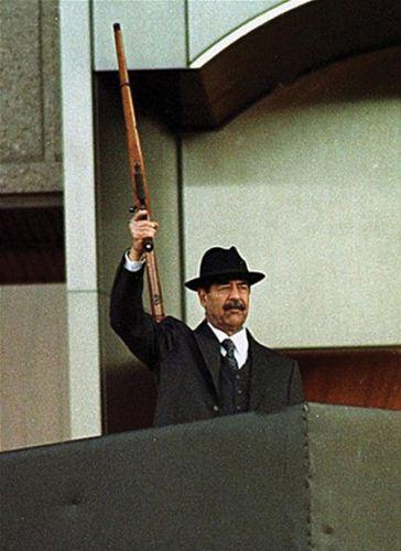 Saddam Hussein dengan senapannya